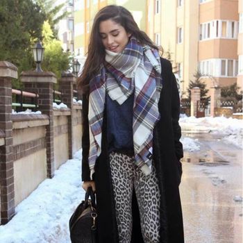 Young woman with bag and large scarf walking in winter